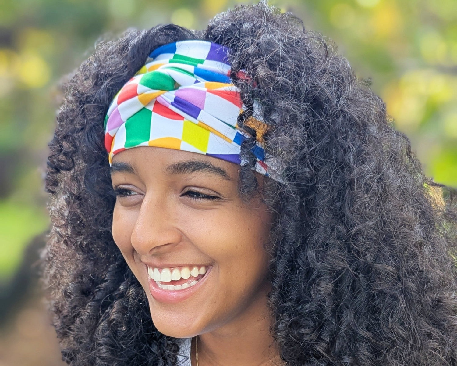 Woman wearing a colorful headband with a blurred natural background