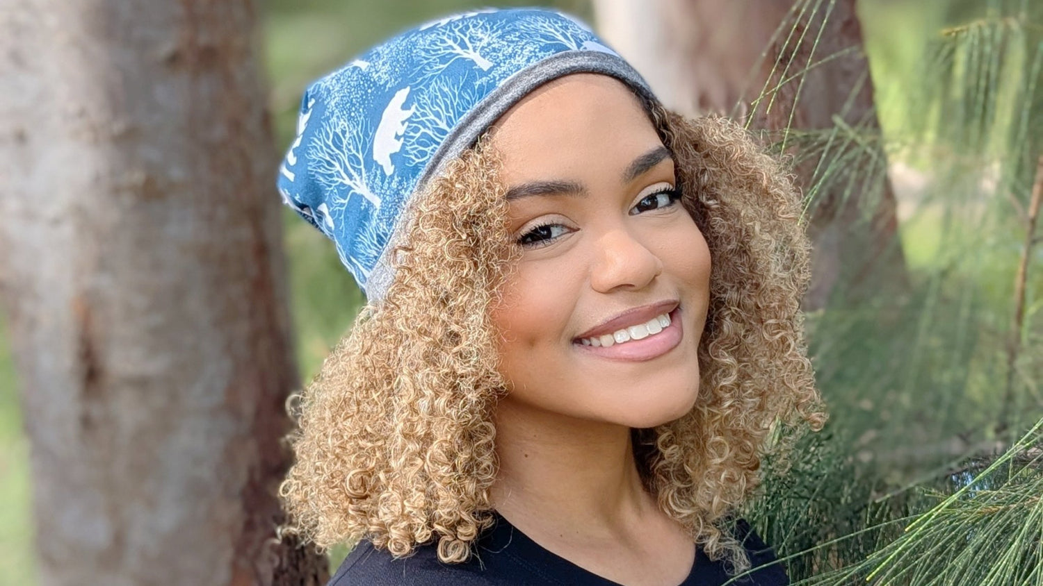 Woman wearing a blue patterned headscarf in a natural setting
