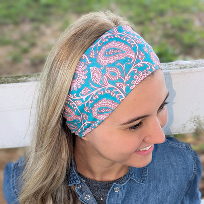 Woman wearing a blue and pink patterned headband with a denim shirt outdoors.